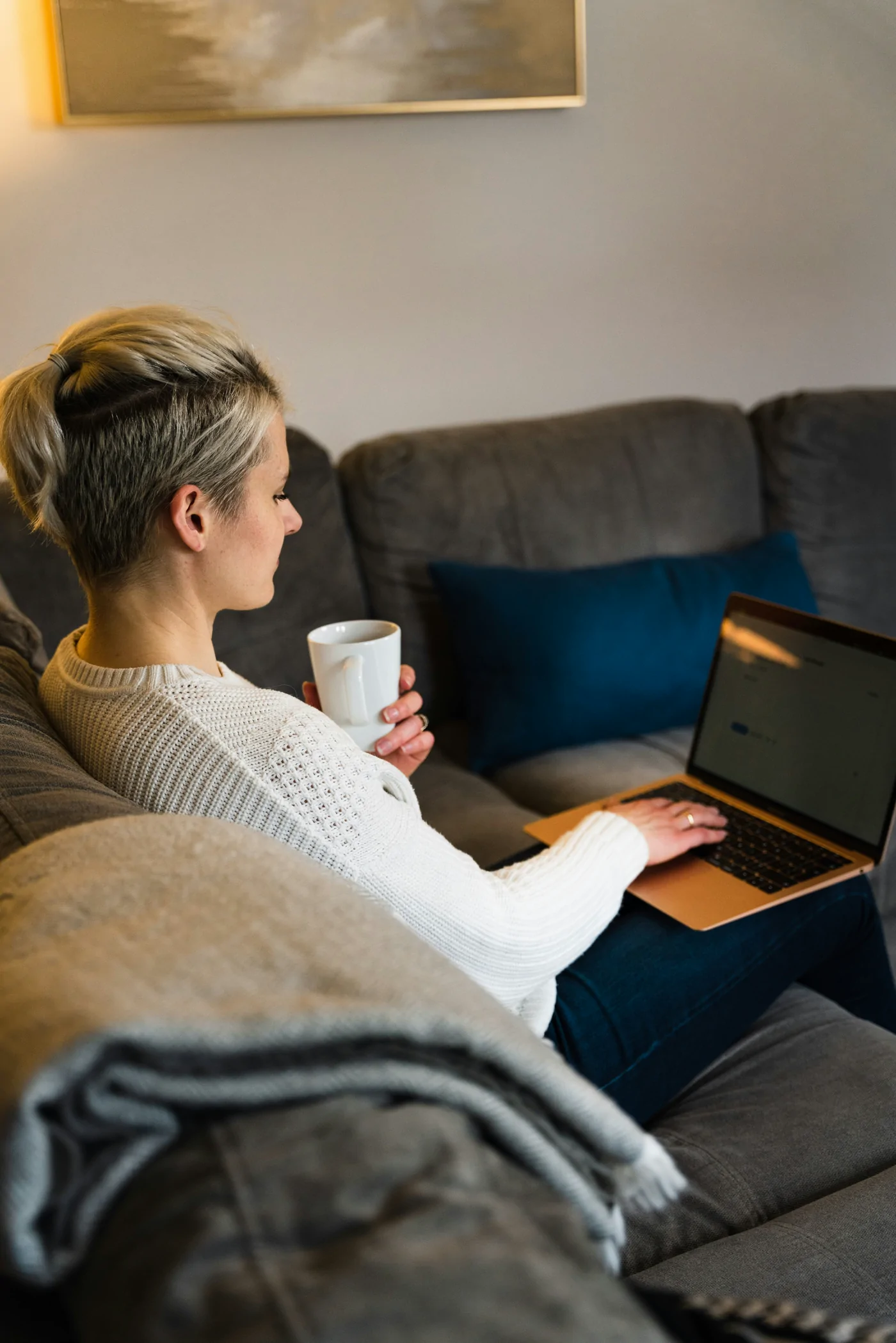 A woman working on a laptop in a furnished living room
